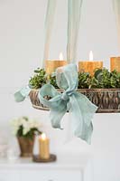 Detail of hanging advent arrangement with gold candles and Eucalyptus and Hebe foliage