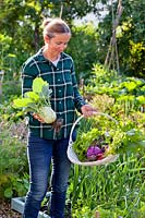 Woman with harvested vegetables.