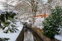 River running through Ston Easton Park garden, Somerset in snow