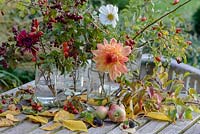 Dahlias with rose hips, Crataegus monogyna - Hawthorn red berries, Cosmos, wild blackberrries - Rubus fruticosus agg, apples and fallen birch leaves, glass jam jars