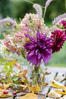 Autumn posie with Dahlias, Hydrangea paniculata and Fountain Grass - Pennisetum alopecuroides 'Hameln' in a glass jar with Birch leaves and rose hips