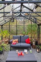 Large greenhouse with lounge furniture, cushions and lighting