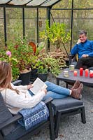 Father and daughter relaxing in lounge furniture in a greenhouse 