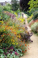 Long border in Autumn  with Tagetes patula  'Cinnabar' in the foreground