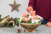 Lighting a candle in a bowl arrangement
