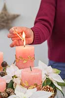 Woman lighting a candle in a bowl arrangement