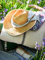 Straw hat with scarf on picnic blanket. 