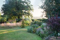 Lawn edged with summer borders and grasses 