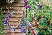 Bunches of dried flowers and wreaths displayed hanging on metal frame