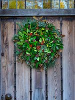 Christmas wreath hanging on an oak door 
