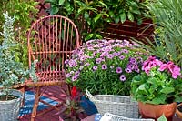 Wicker chair on patio with potted spring containers