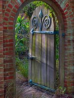 Doorway and arch to the Mediterranean Garden at East Ruston Old Vicarage Gardens, Norfolk, UK. 
