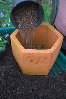 Preparing pots for planting - adding a layer of gravel to help drainage