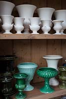 collection of white and green vases and urns in the flower arranging studio. 
