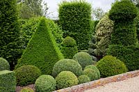 Formal topiary garden with Buxus sempervirens - Box - balls and spirals, Taxus baccata - Yew - pyramids, Ilex aquifolium 'Variegatum' and Prunus lusitanica - Portugese Laurel