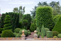 Formal topiary garden with Buxus sempervirens - Box - balls and spirals, Taxus baccata - Yew - pyramids, and Prunus lusitanica - Portugese Laurel. 