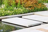 Large sawn Yorkstone floating stepping stone slabs over a water feature. The Sunken Retreat. RHS Malvern Spring Festival, 2016. Design: Ann Walker for Graduate Gardeners