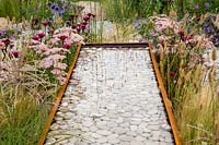 Corten steel water trough water feature filled with white pebbles. Business and Pleasure Garden, RHS Tatton Park Flower Show, 2017. Designer: Jake Curley
