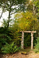 A Japanese style gate made of logs surrounded by ferns and autumn foliage - Windy Hall, Bowness on Windermere, Cumbria, UK
