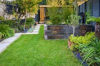 Walthamstow Modern Garden with Raised Bed and view to Garden Room by Earth Designs 