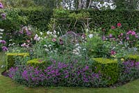 Central bed with box rectangles between plantings of Pennisetum villosum, Verbena hastata, Zinnias, Cosmos, Dahlias, Roses and Phlox.