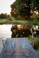 Ornate metal rocking chairs overlooking the pond