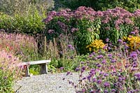 Perennial flower border, rustic oak bench nearby