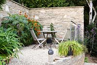 Walled terrace and seating area with Leonotis leonurus and Melianthus major. 