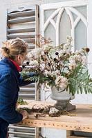 Liz Mobbs making autumnal floral arrangement with foraged materials and dried flowers and seedheads.