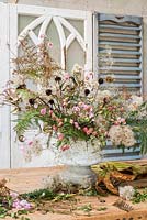 Making a autumnal floral arrangement with foraged and dry florals.