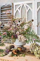 Autumnal floral arrangement in urn with dried and foraged florals inc echinacea, Clematis, bracken, hydrangeas, echinops