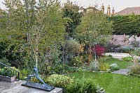 Low maintenance  city garden  Garden view with Acer palmatum 'Bloodgood' and Mike Speller's sculpture