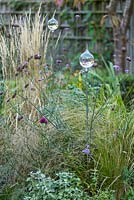 Low maintenance  city garden with grasses and glass garden ornaments