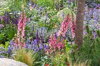 Large natural stones amongst nectar rich mixed summer planting. Garden: The Viking Cruises Lagom Garden - Hampton Court Flower Festival 2019