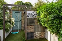 Swing and raised bed with planting gabion wall with bicycle storage by Earth Designs