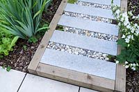 Small modern garden in London, with paving slab stepping stones in gravel infill raised pathway, by Earth Designs.
