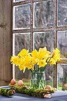 Narcissus - daffodils displayed in vase on windowsill.