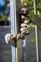 Hanging stone decoration in modern, north London garden by Earth Designs. 