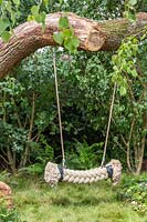 Children's rope swing in shady woodland garden. The Zoflora and Caudwell Children's Wild Garden. RHS Hampton Court Palace Flower Show, 2017. Designers: Adam White and Andree Davies.
