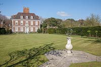 Armillary on stone pedestal beside a bowling lawn fronting a Lutyens house. Garden designed by Gertrude Jekyll and Edwin Lutyens.