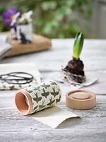 Decorative paper wrapped around former to make plant pot. 