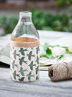 Milk bottle wrapped with decorative papers. 