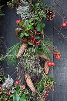 Detail of rustic christmas wreath made with a mix of rosehips, crab apples, pinecones and foliage. Styling: Marieke Nolsen
