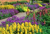 View over colourful mixed flowerbeds with geraniums and lupines. 
