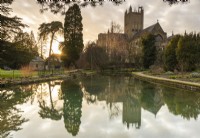 Ponds in the garden at the Bishop's Palace, Wells in March with the imposing form of the cathedral rising behind