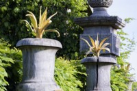 Gilded agaves atop green oak urns in the Collector Earl's Garden at Arundel Castle, West Sussex