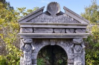 Carved oak temple facade with shell pediment and caryatids that flank the source of an allegorical river in the Collector Earl's Garden at Arundel Castle, West Sussex in May