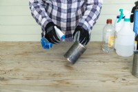 Woman spraying hydrogen peroxide on a tin can