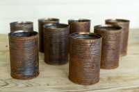 Rusty tin cans on wooden surface