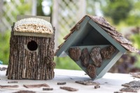 Bird houses on a wooden surface with garden in background